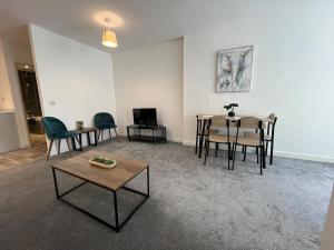 ein Wohnzimmer mit Stühlen und einem Tisch in der Unterkunft Hunters House Flat 6 Sleeps 3 long stays Free Wi-Fi in Swindon