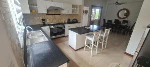 a kitchen with a sink and a stove top oven at Royale Green Villa in Anse Royale