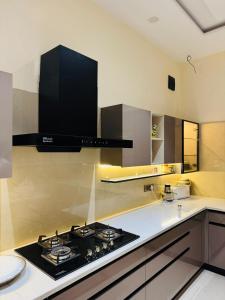 a kitchen with a stove and a counter top at Sukuun in Sri Guru Ram Dass Jee International Airport