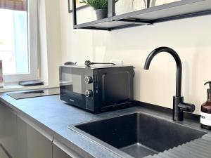 a kitchen counter with a sink and a microwave at My Room Centrale e Moderno Appartamento in Bari