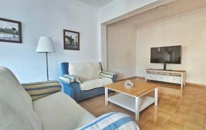 a living room with a couch and a tv at Alojamiento La Alameda in La Aldea de San Nicolas
