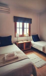 a room with two beds and a window at Alojamiento La Alameda in La Aldea de San Nicolas