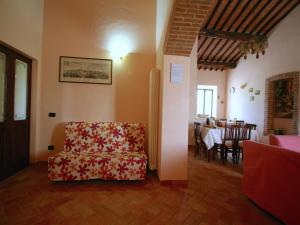 un salon avec une chaise et une table dans l'établissement Lovely Farmhouse in Asciano with Swimming Pool, à Asciano