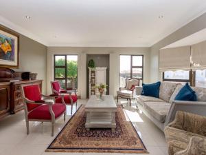 un salon avec un canapé, des chaises et une table dans l'établissement Alabaster Luxe Villa, à Langebaan