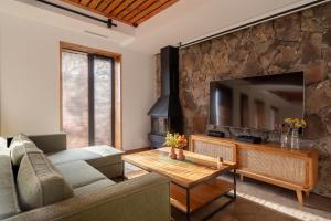 a living room with a couch and a television at Aprie Boutique Hotel in Byurakan