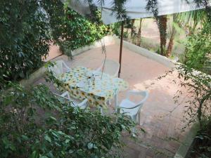 a table and chairs in a patio with an umbrella at Spacious Mansion in Parghelia near Sea in Parghelia
