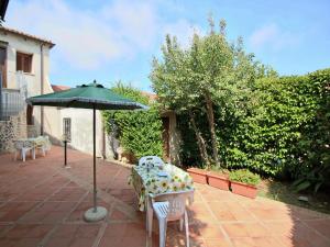 a table with an umbrella on a patio at Spacious Mansion in Parghelia near Sea in Parghelia