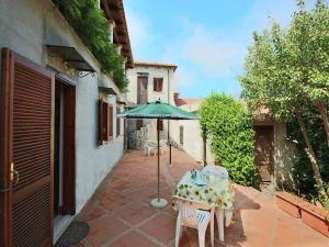 a table with a green umbrella on a patio at Spacious Mansion in Parghelia near Sea in Parghelia
