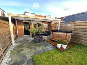 a patio with potted plants and a fence at Fantastic luxury vacation home and next to the Wadden Sea in Paesens