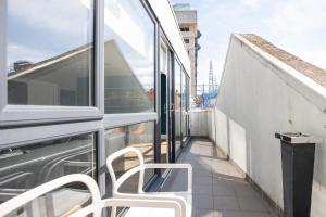 a balcony with two white chairs and a window at Temple Bar Crown Square Apartments in Dublin
