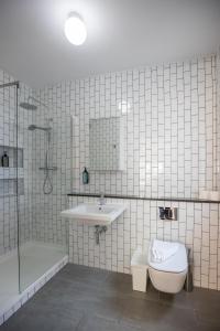 a bathroom with a toilet and a sink and a shower at Temple Bar Crown Square Apartments in Dublin +17 photos