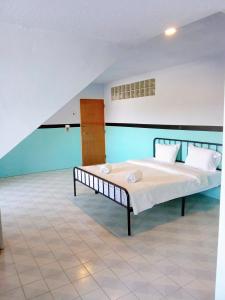 a bedroom with a large bed with white sheets and pillows at Mitr Inn Phuket Oldtown in Phuket Town