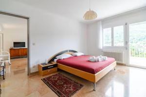a bedroom with a large bed with a red blanket at Villa Caslano in Caslano +30 photos