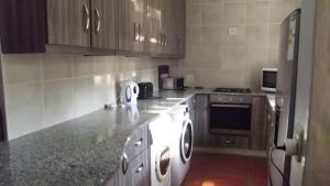 a kitchen with a stove and a white appliance at Caribbean Estates Montego Bay 05 in Port Edward