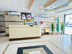 un vestíbulo de un salón con mostrador y plantas en الياس التميز للشقق المخدومة, en Yeda