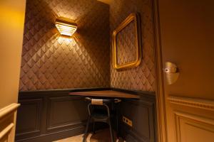 a bar in a room with a stool and a mirror at Hôtel La Particulière in Caen