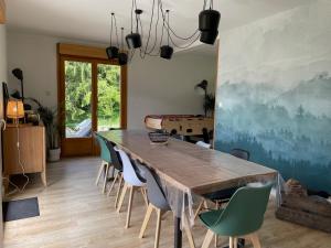a dining room with a wooden table and chairs at La Gouleote Spacieuse maison type chalet avec jacuzzi, sauna, pétanque in Gérardmer
