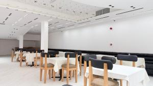 a room with tables and chairs and a white wall at Palette Sharjah Aparthotel formerly Royal Tulip in Sharjah