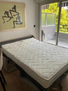 a large bed in a room with a window at Studio cuisine parking piscine à Cannes in Cannes +37 photos