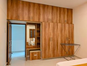 a room with wooden cabinets and a mirror at Yellowra Farmstay Tiruvannamalai in Tiruvannāmalai
