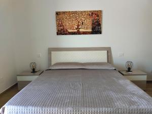 a bed in a bedroom with a painting on the wall at Granatelli Holiday Home in Altavilla Milicia +54 photos