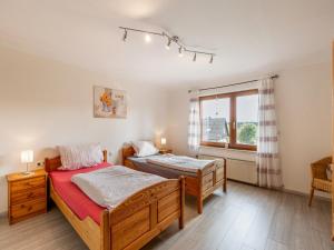 キルヒウンデムにあるBezaubernde Ferienwohnung in Kirchhundemのベッド2台と窓のある寝室