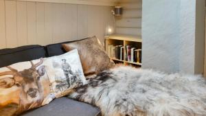 a blanket on a couch with a book shelf at Historic Hunting Lodge By Lake Øyangen in Hønefoss