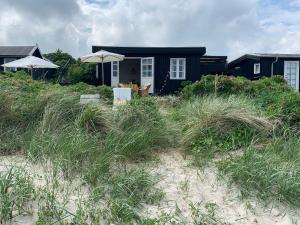 a house on the beach with tall grass at Beachfront House At Hølken Beach in Odder +17 photos