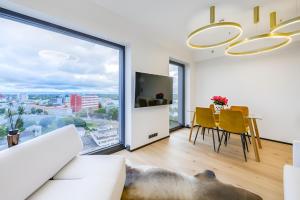 a living room with a table and a large window at Luxury apartment, outstanding view, free parking in Tallinn
