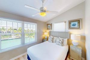 una camera da letto con un letto e un ventilatore a soffitto di Key Lime Villa a Duck Key Altre 22 foto