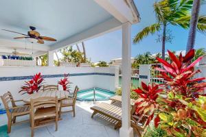 a patio with a table and chairs and a swimming pool at Key Lime Villa in Duck Key