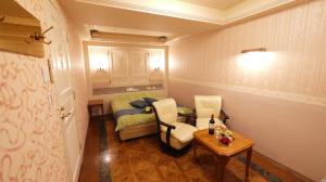 een kleine kamer met een bed en een tafel en stoelen bij HOTEL井原商事ハートランド井門 Adult only in Tokyo +20 foto's