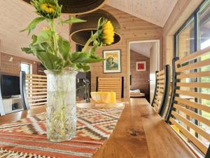 a vase of flowers sitting on a wooden table at Seaside Cabin With Panoramic Views In Alvundfjord in Ålvundeid