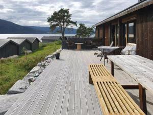 a wooden deck with two benches and a table at Seaside Cabin With Panoramic Views In Alvundfjord in Ålvundeid