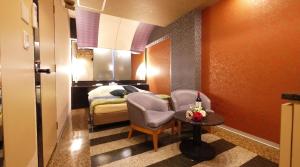 een hotelkamer met een bed, een tafel en stoelen bij HOTEL井原商事ハートランド井門 Adult only in Tokyo
