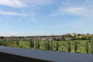 Una vista de un campo y árboles desde la ventana de un tren. en NEWTON30 - Luminoso bilocale in zona servita, en Rávena