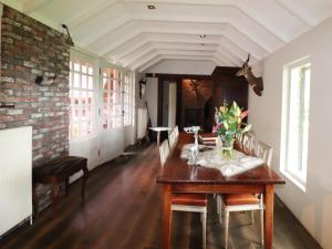 a dining room with a table with flowers on it at Villa in Ommen with Private Pond in Rheezerveen