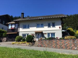 a large white house with a brick wall at Modern Escape in Niedersfeld in Winterberg