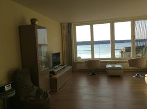 ein Wohnzimmer mit Blick auf den Strand in der Unterkunft Ferienwohnung Sonwik in Flensburg