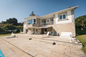 a cat standing on a patio in front of a house at Chalet Veiga da Area in Combarro