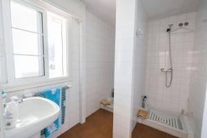 a white bathroom with a sink and a shower at Chalet Veiga da Area in Combarro +23 photos