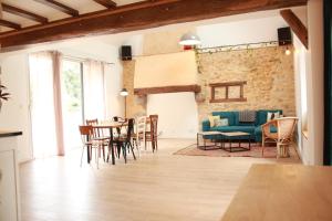 una sala de estar con una mesa y sillas en Gite de groupe "Le Réveillon", en Neuville-sur-Sarthe