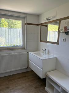 a white bathroom with a sink and a window at Gästezimmer Schupanez in Leutschach