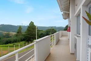 a balcony with a view of the mountains at Apartamentos estilo loft pertinho da rota do vinho in São Roque