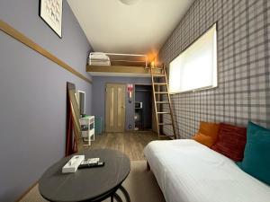 東京にあるLARK OKUBO Free wifiのベッドルーム1室(ベッド1台、テーブル、はしご付)