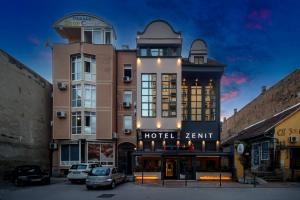 a hotel with cars parked in front of a building at Garni Hotel Zenit in Novi Sad