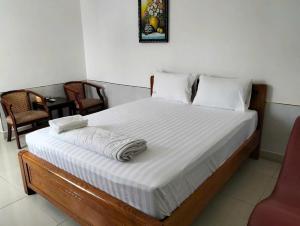 Khải Lộc Minh Hotel Hồ Chí Minh في مدينة هوشي منه: غرفة نوم بها سرير عليه منشفتان
