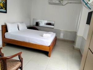 Khải Lộc Minh Hotel Hồ Chí Minh في مدينة هوشي منه: غرفة نوم صغيرة بها سرير وكرسي