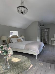 a bedroom with a bed and a table with a vase of flowers at Loughanmore Court Cottage in Dundalk