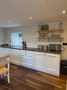 a kitchen with white cabinets and a counter top at Loughanmore Court Cottage in Dundalk +8 photos